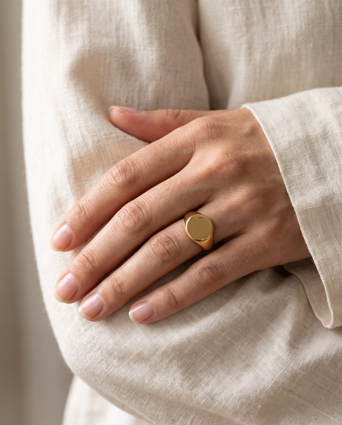 Woman's hand wearing the gold-plated Oval Signet Ring