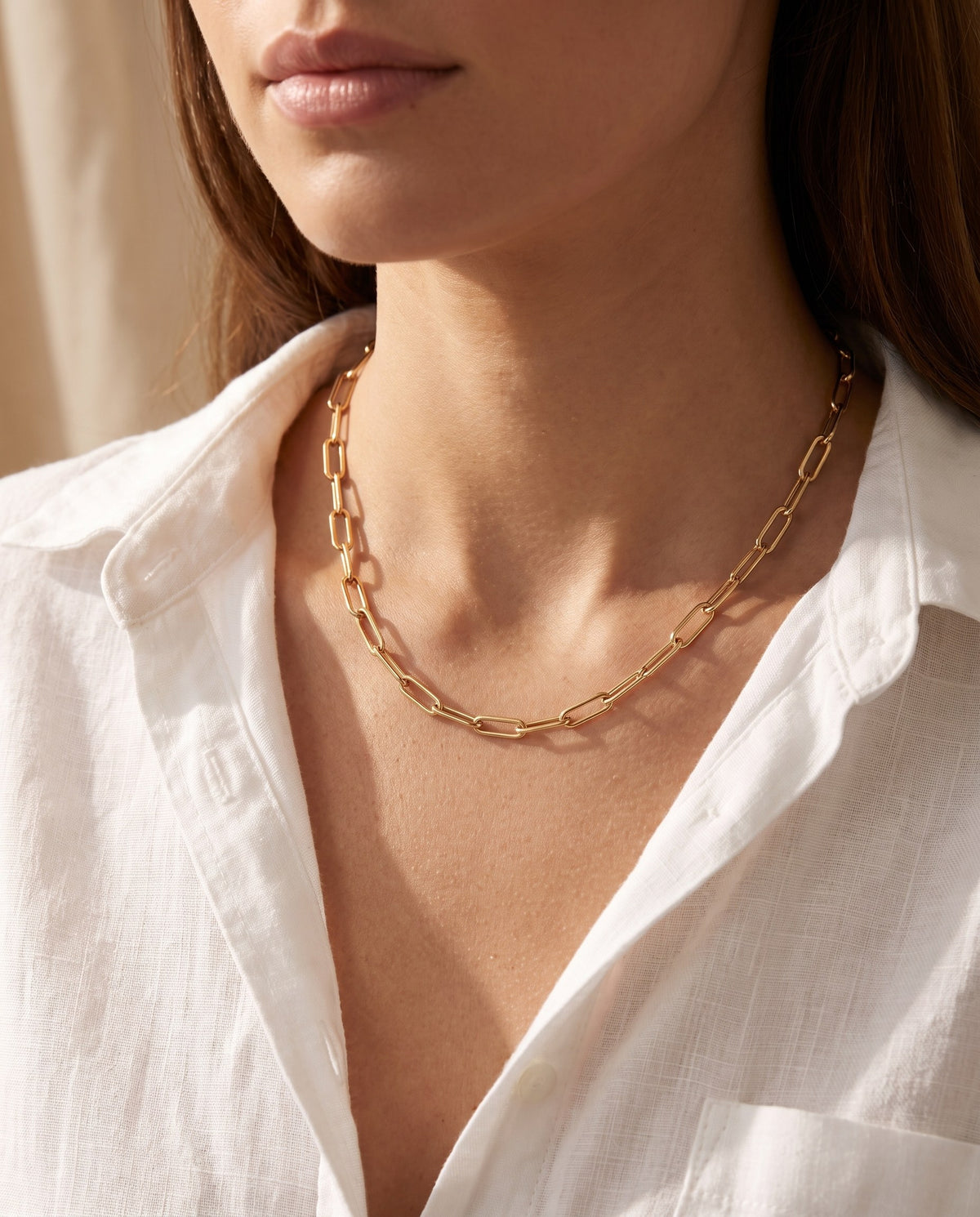 Woman wearing the gold-plated Paperclip Chain Necklace with a white open-neck shirt