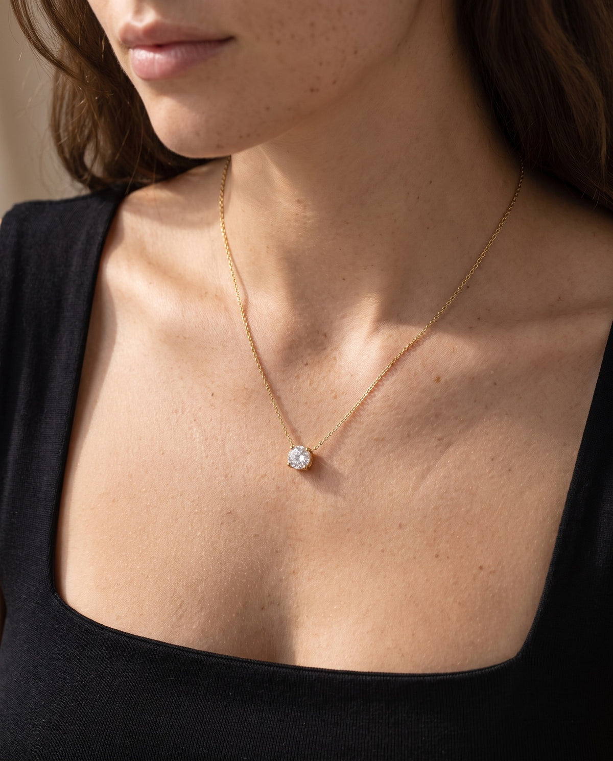 Woman wearing the Solitaire Pendant Necklace with a black top