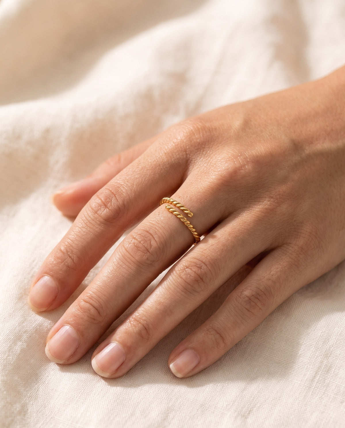 Woman's hand wearing the gold-plated Twisted Open Ring